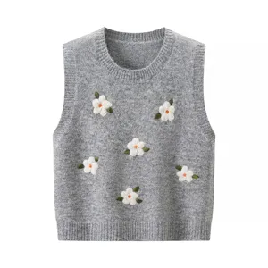 Primer plano del chaleco de punto gris con bordado floral 3D, cuello redondo y textura.