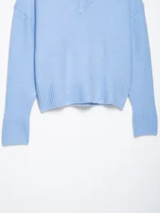 Light blue V-neck knit sweater detail view, showing ribbed cuff and soft texture.