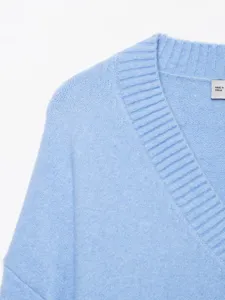 Detailed view of the light blue V-neck knit sweater, showcasing soft texture and collar detail.