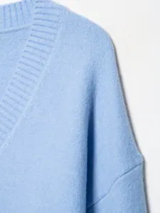 Light blue V-neck knit sweater closeup detail, soft texture and cozy fabric design.