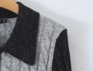 Detail view of the color-blocked cable knit retro lapel sweater texture and collar.