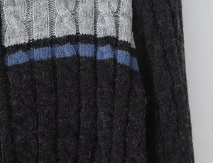 Close-up detail shot of women color-block cable knit sweater showing texture and stitching.