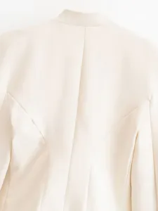 Detail shot of the back of a beige women's stand-collar slim blazer showing structured seams.