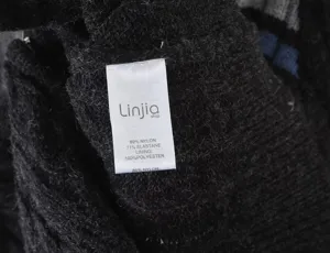 Women knitwear detail view showing wash care label with nylon and polyester material specs.