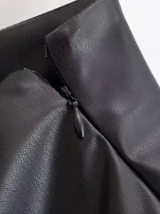 Black faux leather jacket detail close-up, premium texture and zipper design for women.