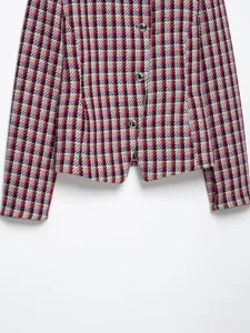 Detailed view of women structured tweed blazer jacket, colorful plaid fabric, metal buttons.
