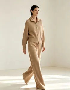 Detail view of a chic solid color knit zip-up cardigan and matching trousers set.