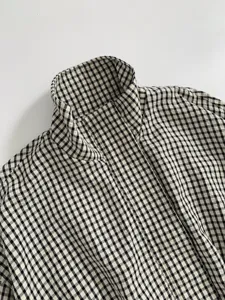 Close up view of women's black and white plaid stand collar jacket detail texture