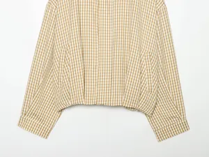 Close-up detail view of the casual khaki gingham plaid short jacket pocket and sleeve.