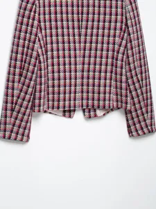 Close-up detail of women's colorful tweed blazer jacket with woven plaid pattern texture.