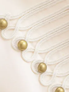 Detailed view of women's court style blazer featuring intricate white braided cords and gold buttons.