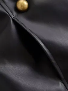 Detailed close-up view of black faux leather apparel texture with vintage brass button accent.