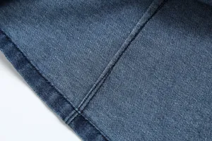 Detailed close-up shot of high quality blue denim fabric with neat stitching and durable weave.