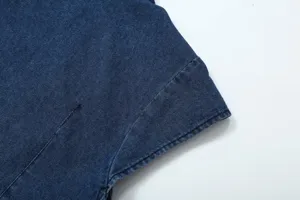 Close-up detail of dark blue denim fabric showing stitching and construction quality.