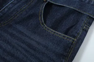 Close-up of dark blue denim fabric with contrast yellow stitching and pocket detail.