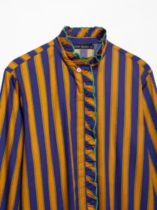 Detailed view of women long sleeve striped shirt with ruffled collar and button front design.