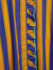 Close-up detail of women's striped shirt featuring vibrant vertical lines and ruffled trim.