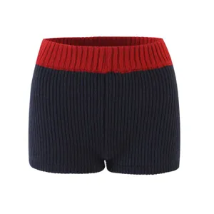 Detail view of high-waist knit shorts with contrast red ribbed waistband and navy texture.