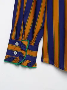 Detailed view of the striped long sleeve shirt cuff with ruffle trim and buttons.