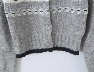 Detailed view of womens vintage elk jacquard knit cardigan with buttons and ribbed hem.