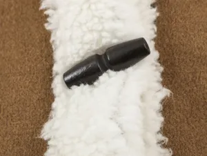 Close-up detail of women's brown jacket faux shearling trim with dark wooden toggle button.