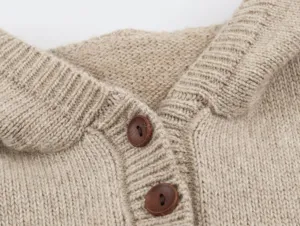 Primer plano detallado de la textura del cuello y botones de chaleco de punto.
