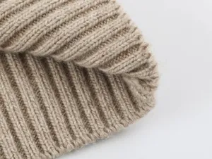 Primer plano de la textura de tela de punto, material acanalado beige suave para diseño.
