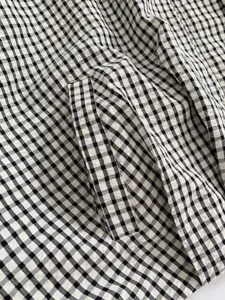 Close-up detail shot of the classic black and white gingham checkered fabric texture pattern.