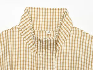 Close-up of the stylish brown and white plaid stand collar jacket collar detail showing texture.