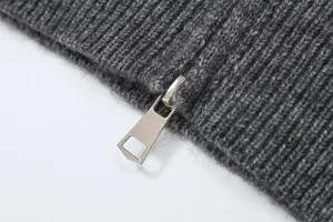 Close-up detail of dark grey knit cardigan fabric showing texture and metal zipper pull.