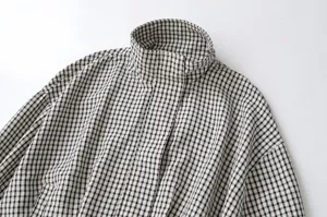Checkered jacket detail view, black and white gingham pattern, stand collar design.