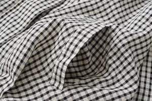 Black and white gingham plaid jacket detail, casual short outerwear with pocket and texture.