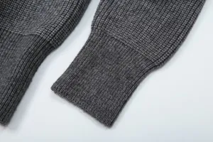 Dark gray knitwear sleeve detail, ribbed cuff texture close-up shot showing fabric quality.