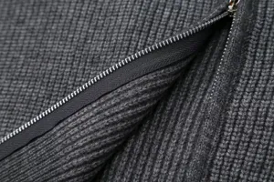 Detailed close-up view of dark gray knitted cardigan fabric texture and metal zipper hardware.