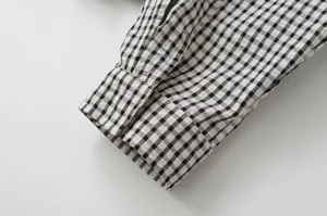 Black and white plaid sleeve cuff detail of casual women jacket product photography.