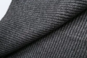 Close-up detail of dark gray ribbed knit fabric showing soft texture and premium quality.