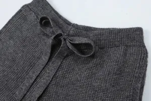 Dark grey knit pants waistband detail, soft textured fabric with adjustable drawstring.