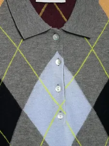 Nahaufnahme Detail des Damen Vintage Argyle Strick Polo Pullovers mit Knöpfen und Mustern.