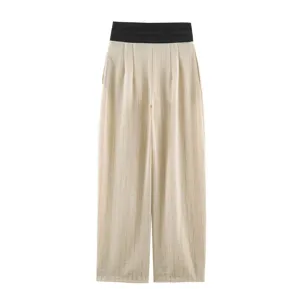 Detailed view of women's high-waist wide-leg trousers in beige with black waistband.