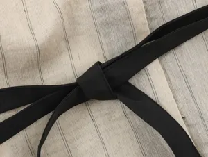 Close-up detail of New Chinese style women's striped top with black waist belt knot.