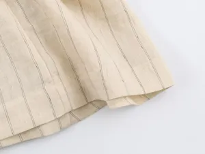 Close-up of lightweight striped linen blend fabric with fine black pinstripes and neat stitching.