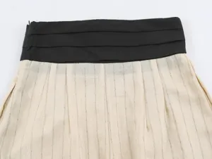 Close-up detail shot of women's stylish color-block pleated wide waistband with striped fabric.