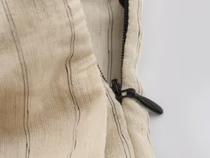 Close-up detail of the striped fabric and black zipper on women's clothing, fine texture.