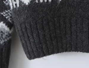 Close-up detail of knitted sweater hem featuring classic Fair Isle pattern and ribbed design.