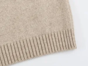 Primer plano detallado del dobladillo de punto acanalado en un chaleco sin mangas beige.