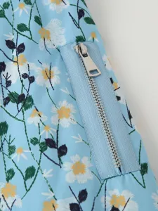 Blue floral embroidered jacket detail with zipper pocket, showing fabric and metal hardware.