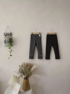 Vista dettagliata di leggings autunnali da bambina con ricamo di gatto in grigio e nero.