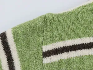 Close-up detail of women green striped knitted sweater, soft fabric texture and neat seams.