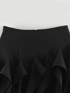 Black ruffled skirt detail view showing asymmetric hem design and soft draping fabric.