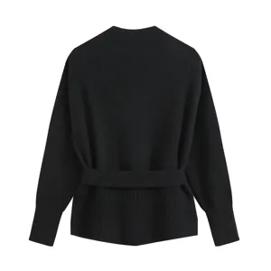 Close-up detail of the black knitted sweater showing the ribbed high collar and waist belt.